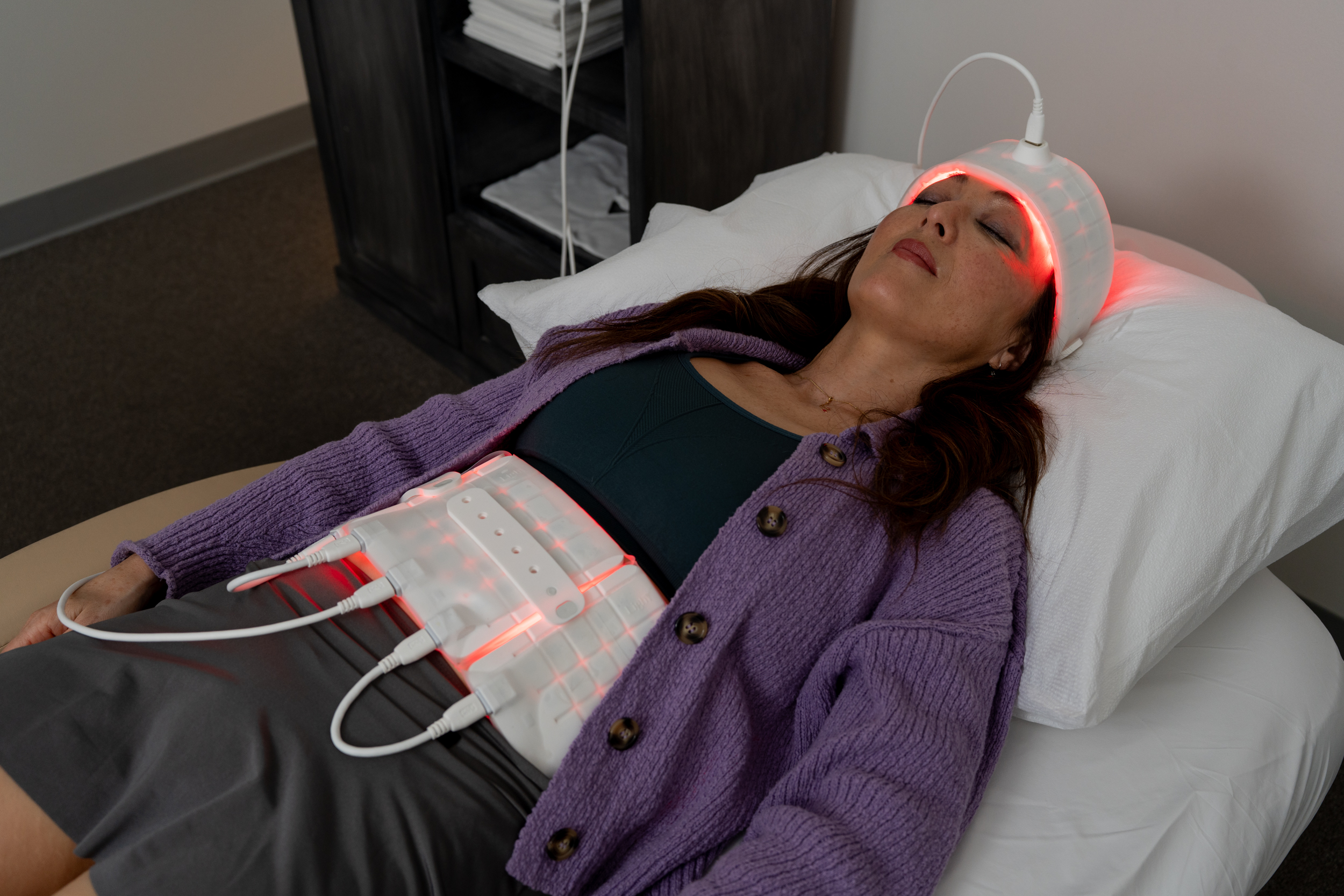 Middle-aged woman receiving UltraRed Light photobiomodulation therapy on the brain and gut to support relaxation, mood balance, and the gut-brain axis