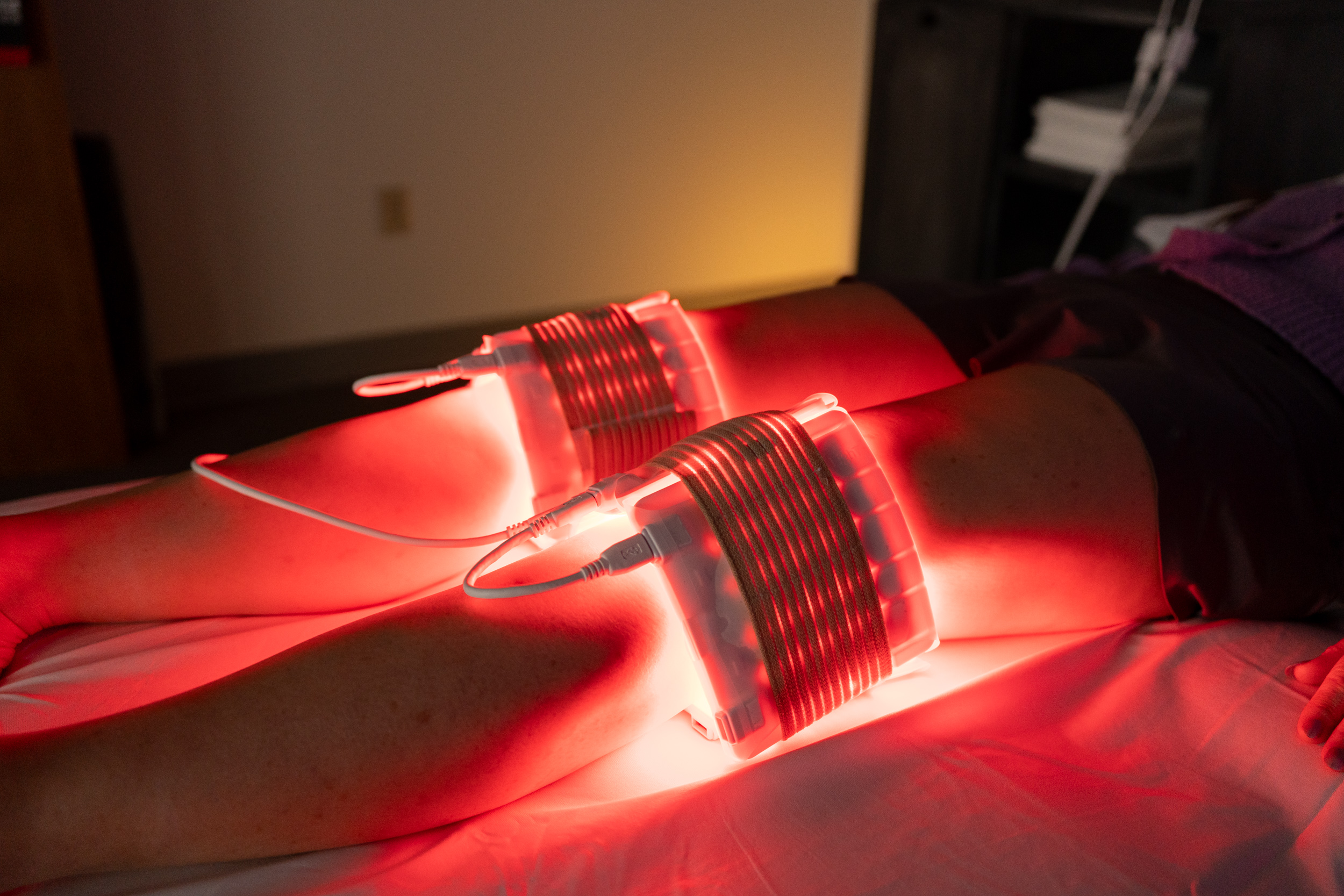 Athlete using UltraRed Light PBM pads on knees to accelerate recovery, reduce knee pain, reduce stiffness.