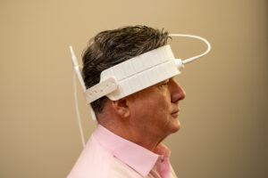 Side view of a man wearing a white LED headband for light therapy